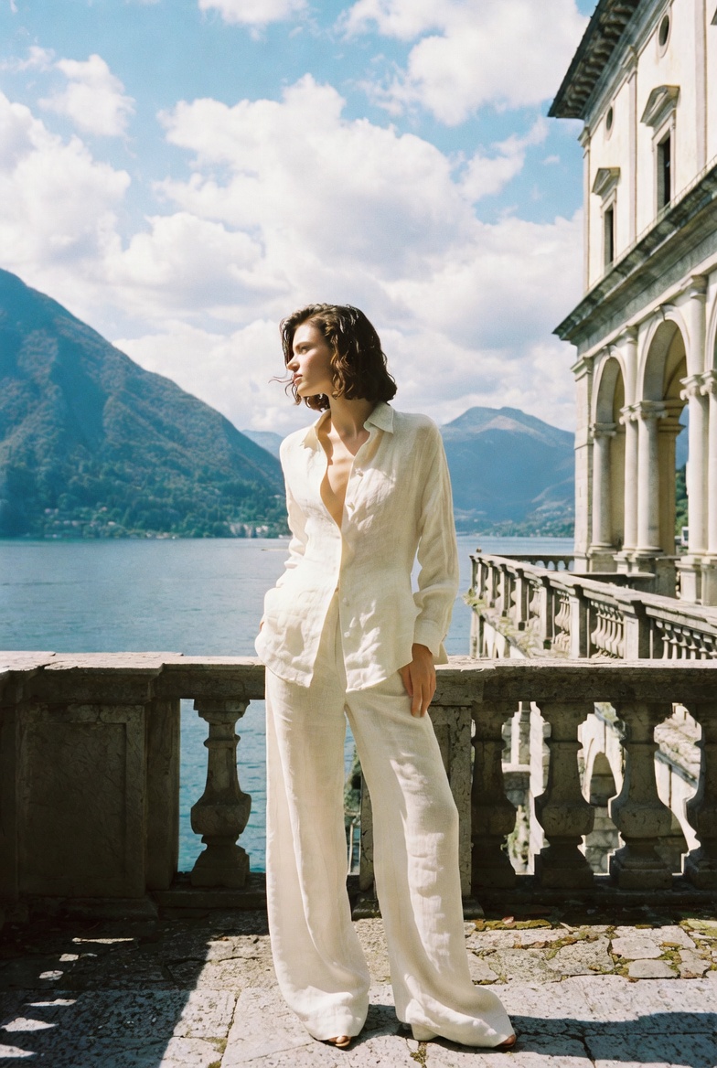 A woman in a linen shirt and trousers at Lake Como, ESVRA Power of Linen edit