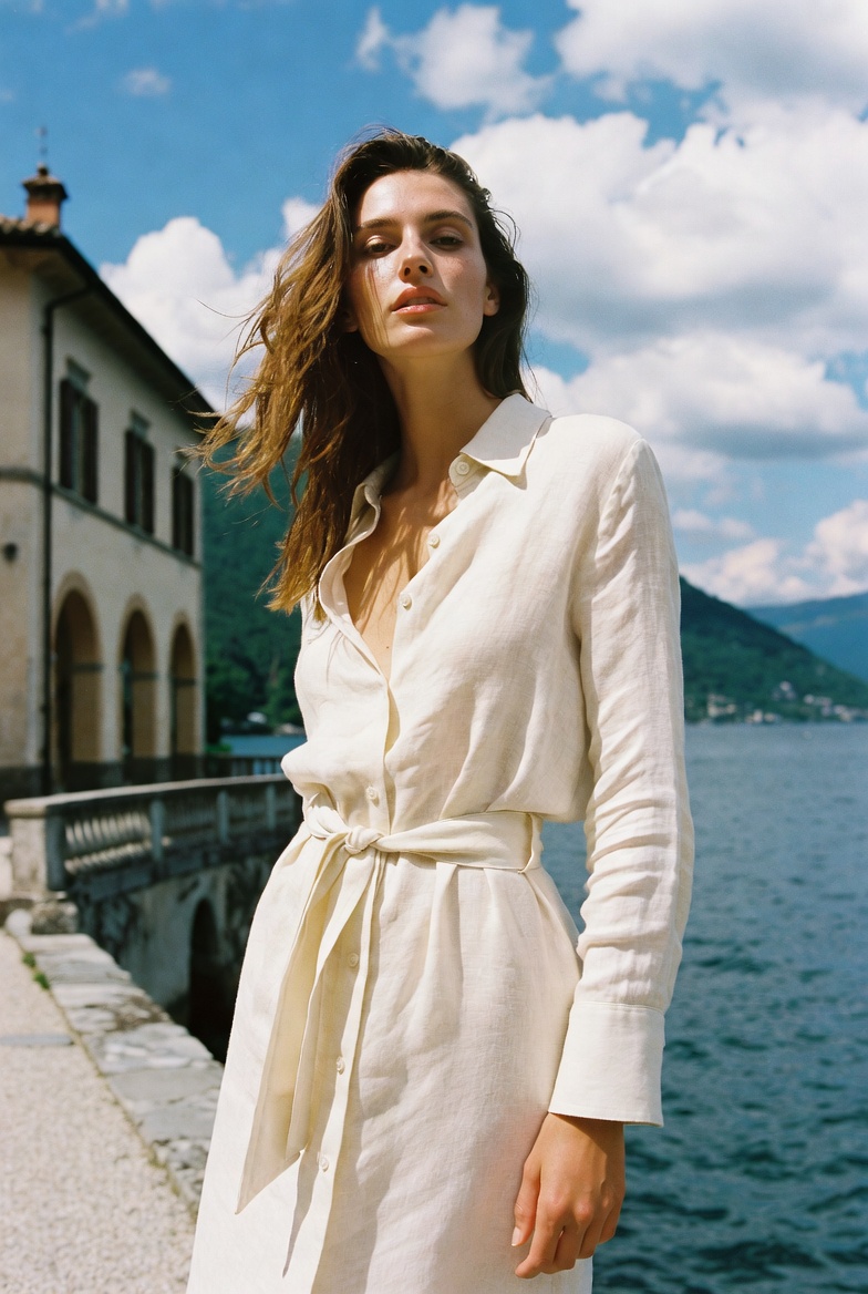 A woman in a belted linen shirt dress at Lake Como, ESVRA Power of Linen edit