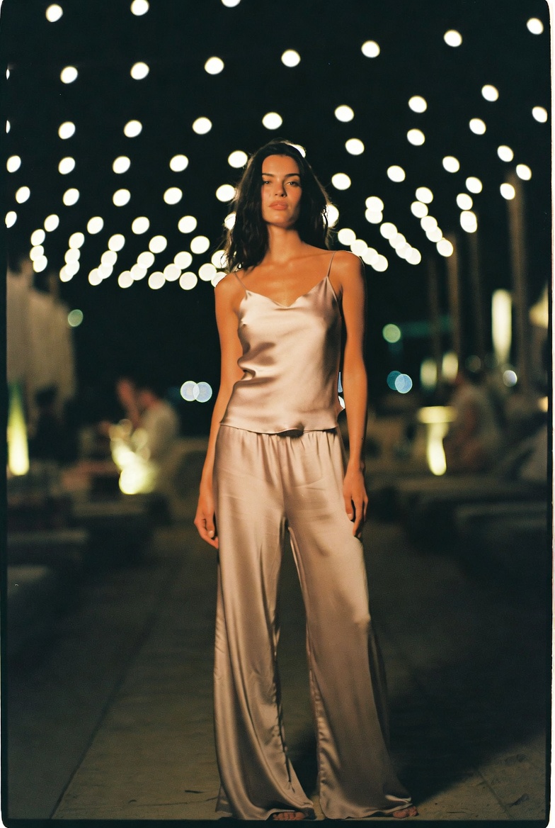 A woman in fluid silk in the evening on a Mediterranean terrace, ESVRA Liquid Silk night edit