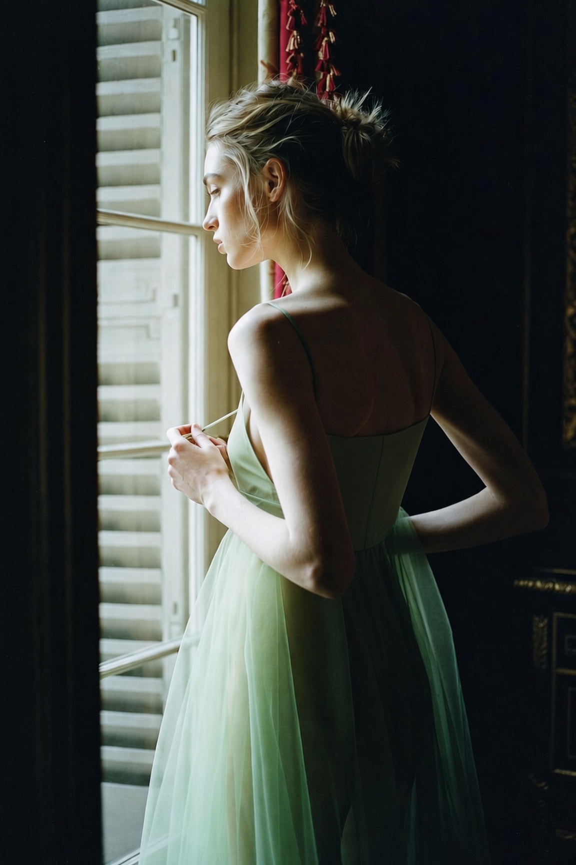 The Sheer Layer — a lined green sheer tulle midi dress worn with black heeled sandals in a Paris hotel room, the ESVRA edit on how to wear sheer for fall 2026