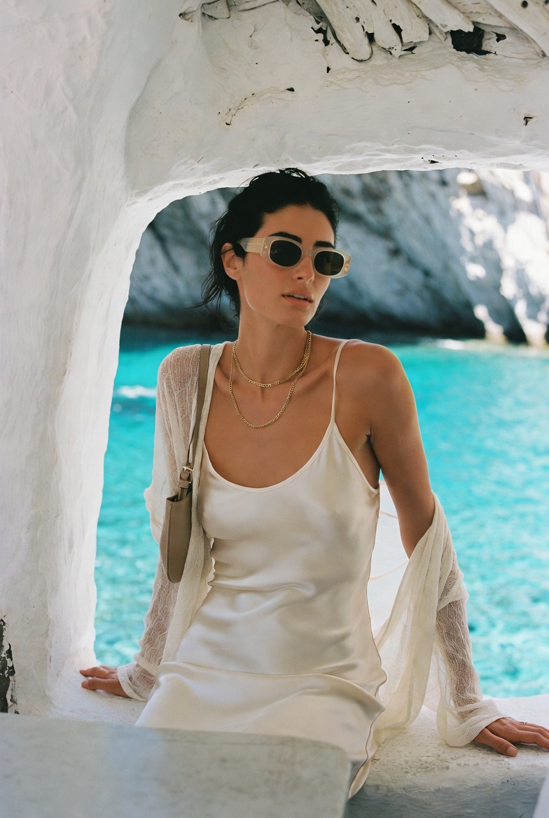 A woman in an oyster slip at a seaside cave taverna in Mykonos
