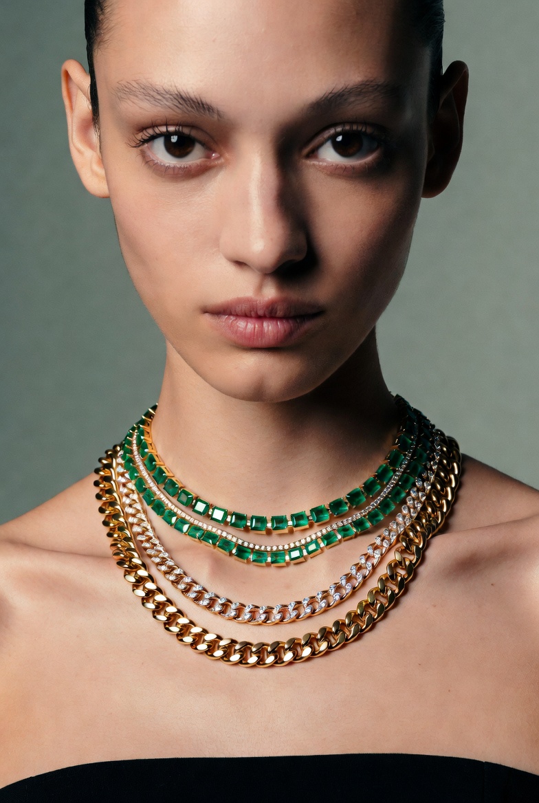 A model wearing a diamond and emerald investment necklace