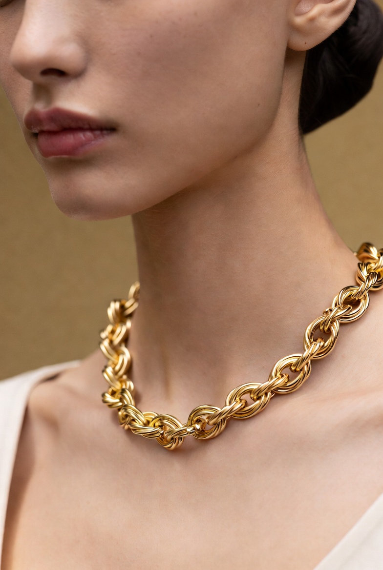 A model wearing a sculptural gold lock necklace