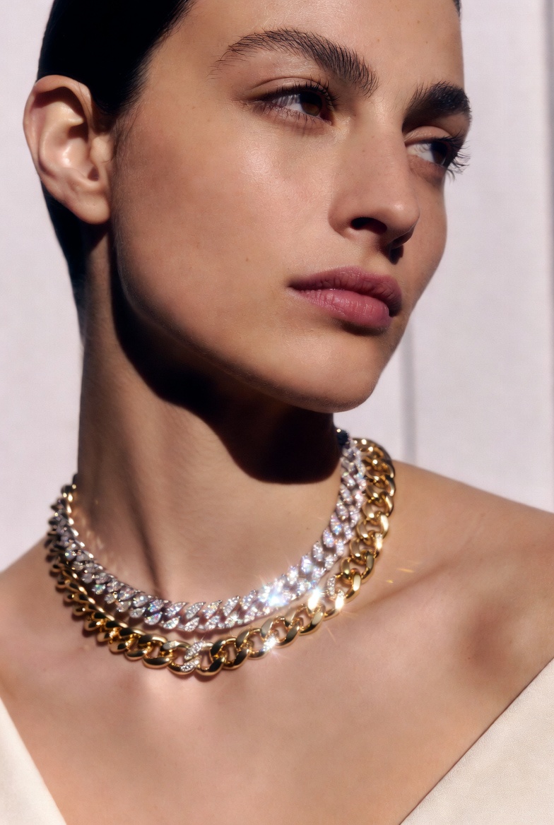 A model wearing layered investment necklaces